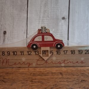 An advent calendar that is a length of wood that is 40cm and has a red car on top with an arrow with a window that slides from left to right marking the days til Christmas
