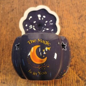 Midnight-blue ceramic oil burner shaped like a pumpkin is both functional and decorative, with golden stars and a crescent moon for added magic
